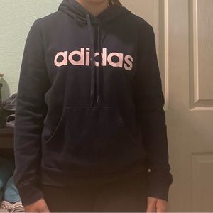 from adidas, size medium, and is black with light pink letters